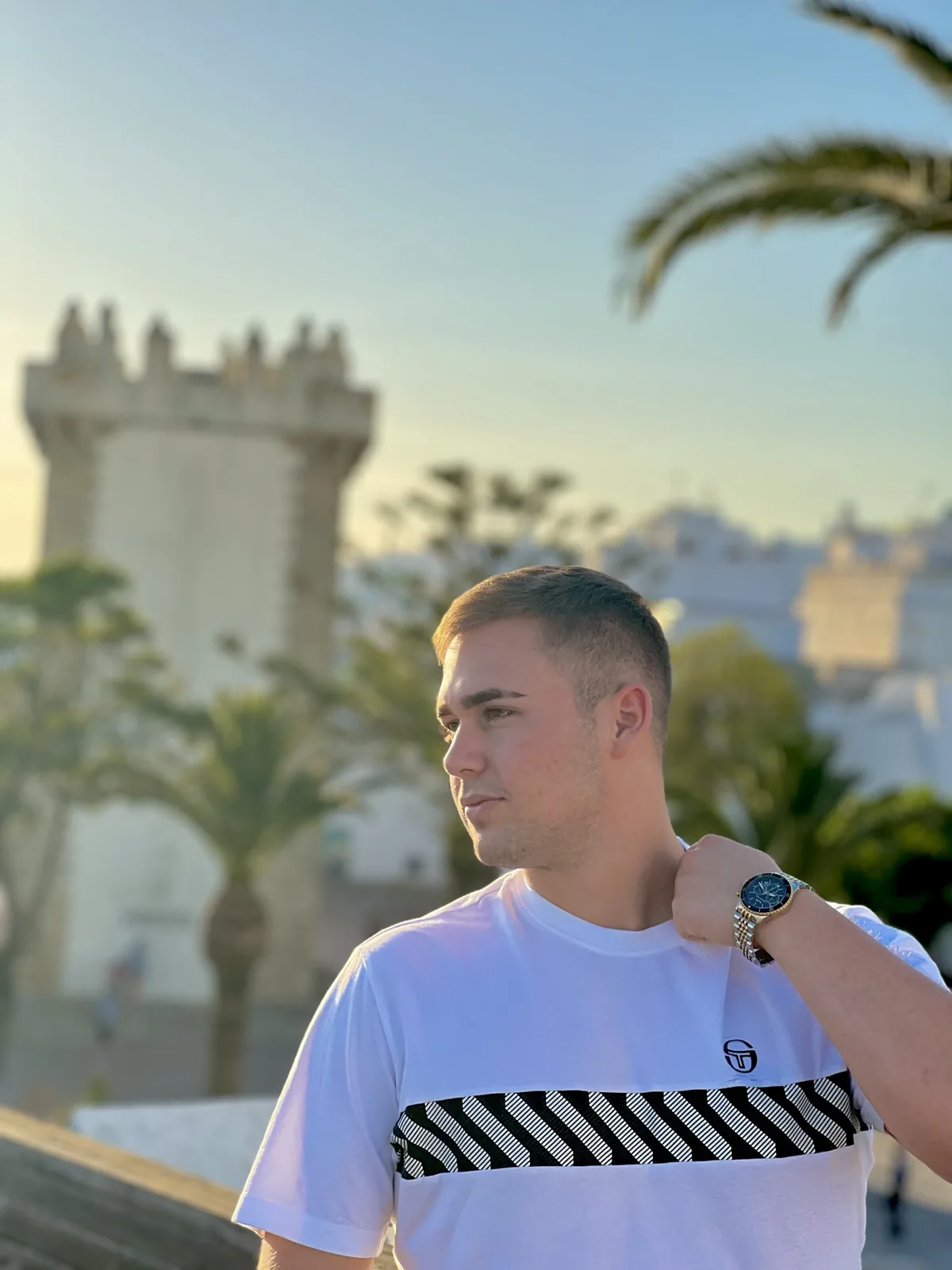 Valentín in Conil, with the Torre de Guzmán and palm trees behind him.
