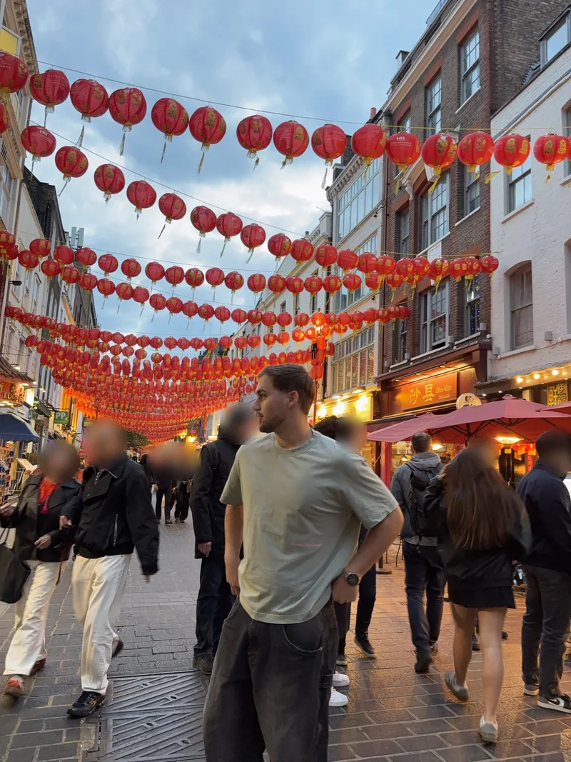 Valentín under red lanterns in a crowded street.