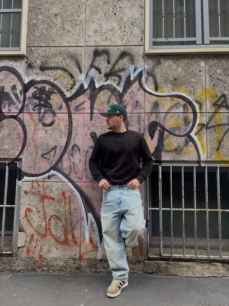 Valentín leaning on the graffiti wall.